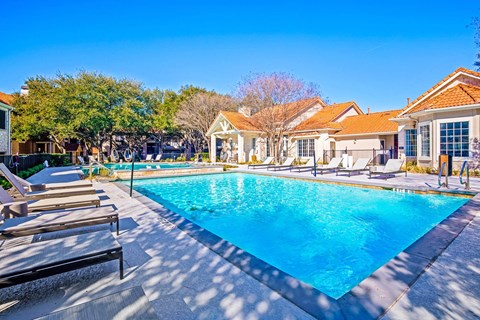 a swimming pool with chairs around it in front of a house at The Olivine, Texas, 78727